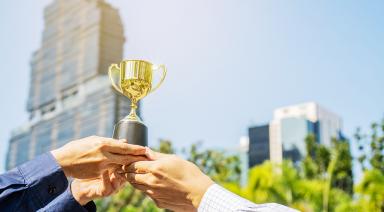 Businessman-Team-Holding-Award-367419283