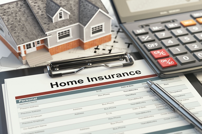 "home insurance form on clipboard next to calculator and small house"
