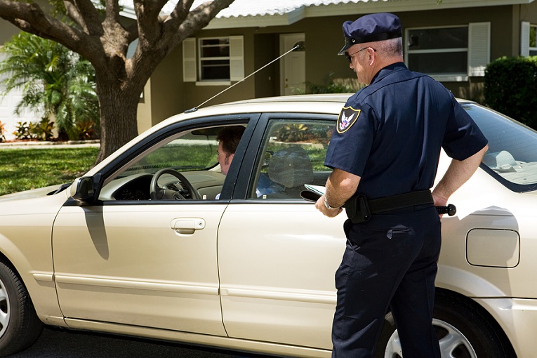 "man pulling over beige car"