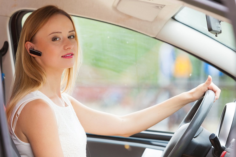 "woman with bluetooth driving in car"