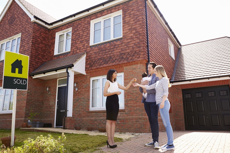 people standing in front of house taking key with baby image