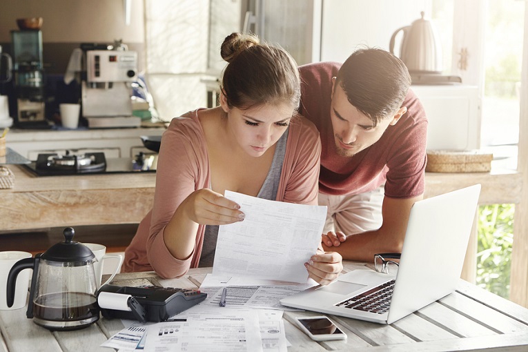 "couple looking at papers together"