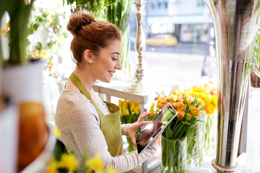 "woman with red hair smiling at plants"