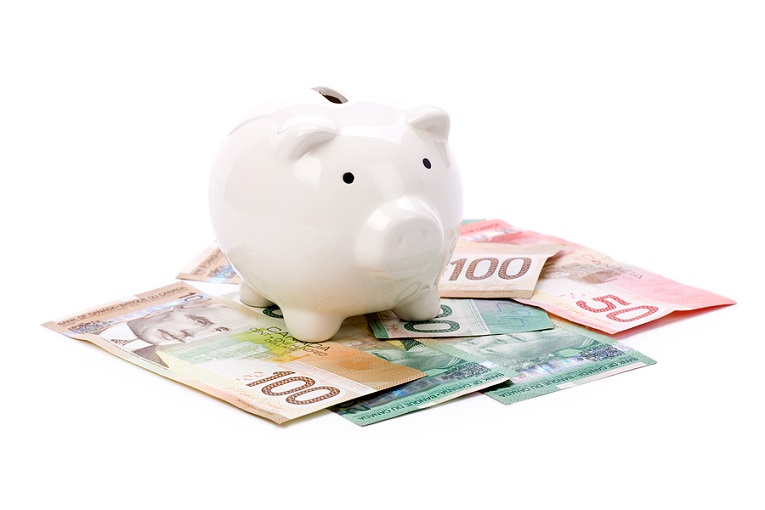 "piggy bank on top of Canadian Money"