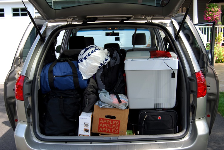  trunk of silver van packed with boxes, bags, and storage containers