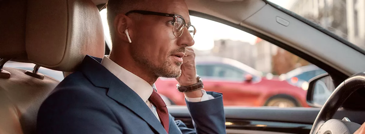 man driving car wearing headphones