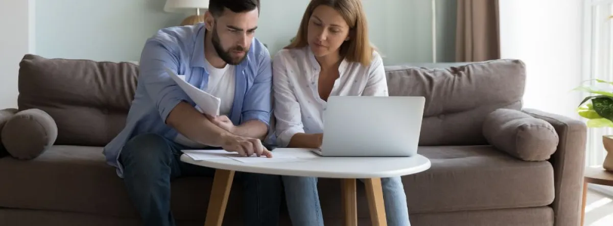 couple on couch looking at paperwork