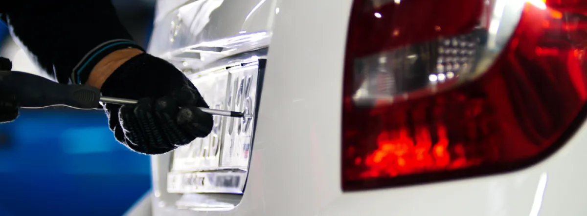 person putting a licence plate on car