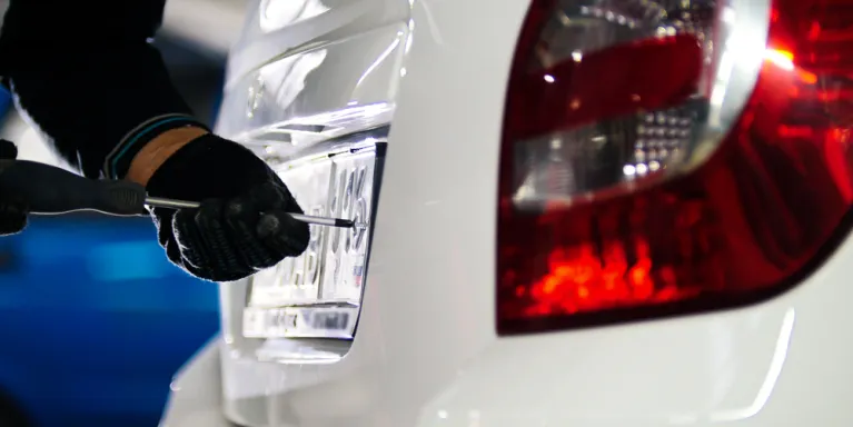 person putting a licence plate on car