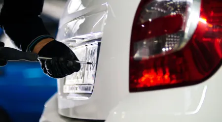 person putting a licence plate on car