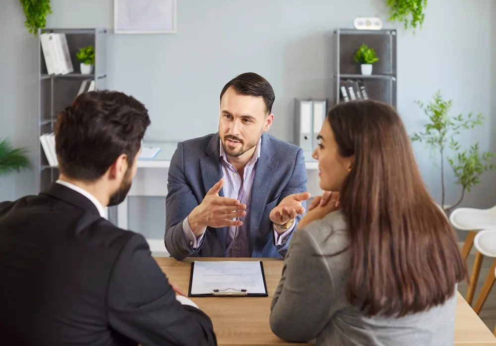 couple talking to person at desk